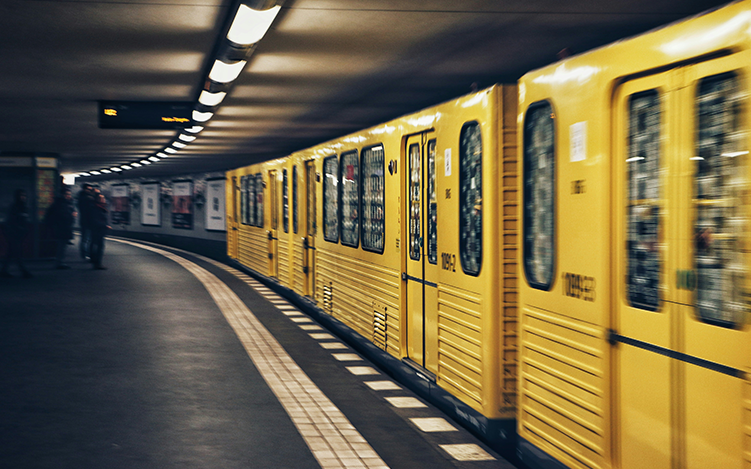 Yellow train passing by in an underground train station