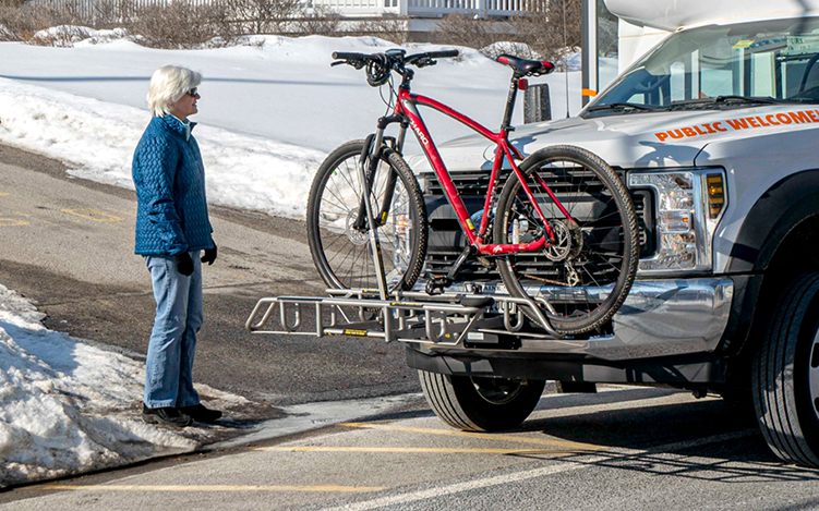 Older women waiting for bike on front of truck
